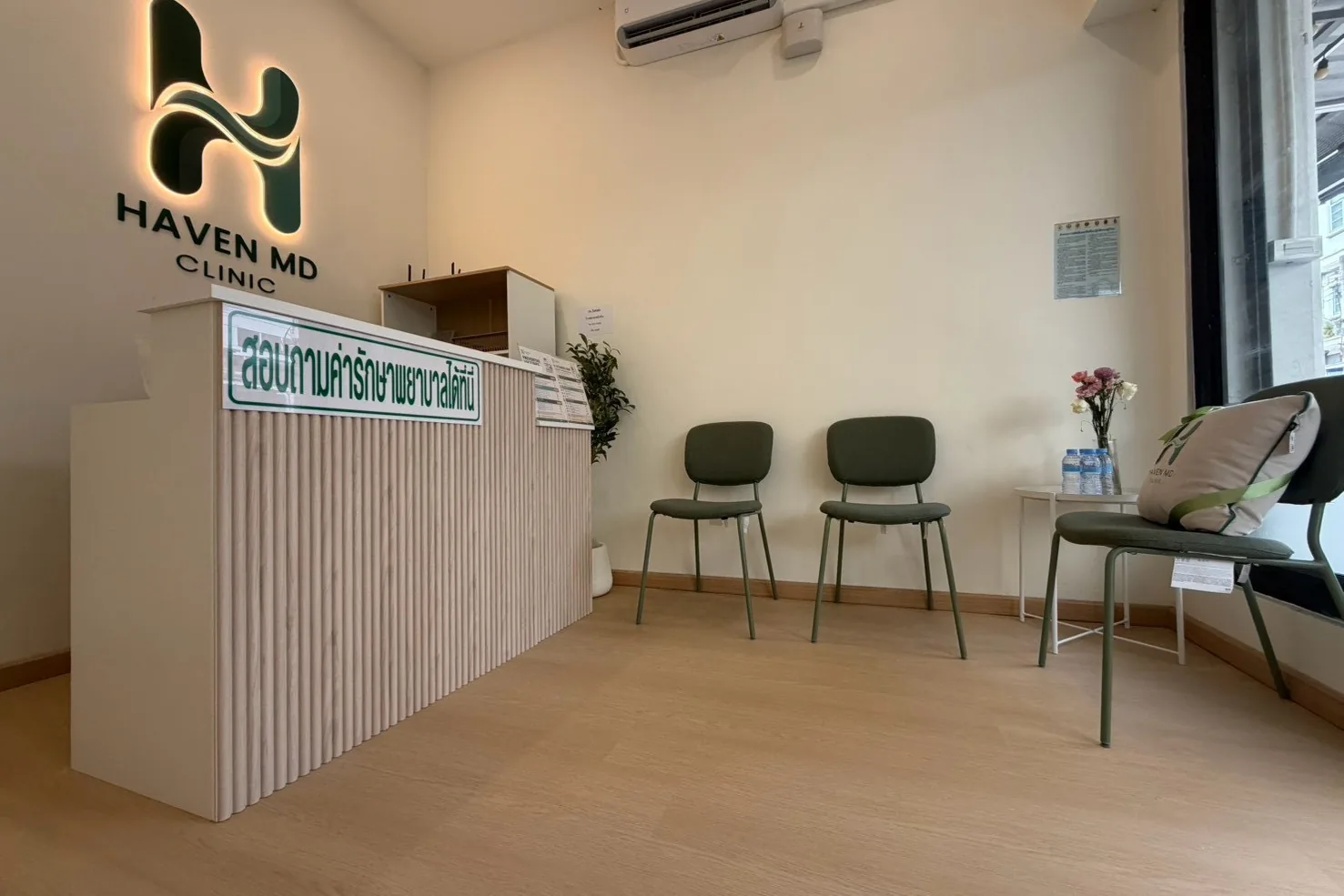 Haven MD Clinic 的前台,柜台上方是发光的诊所标识,旁边设有候诊座椅